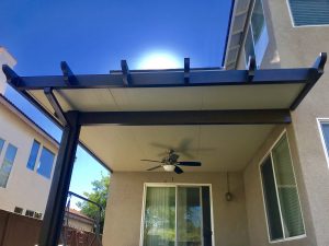 Corner patio cover with ceiling fan done by Superior Patios