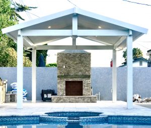 Custom white gazebo with fireplace next to a pool