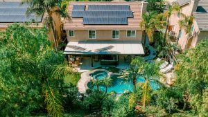 Aerial view of a two-story house with a pool and a patio cover installed by Superior Patios