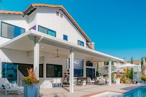 White patio cover install on a white house