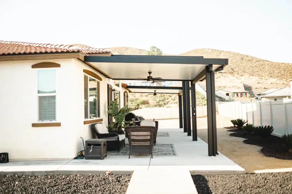 Contemporary aluminum patio cover with ceiling fans and outdoor seating against a desert landscape backdrop