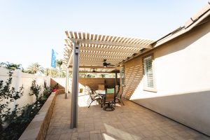 Attached pergola with two posts providing shade during a warm morning